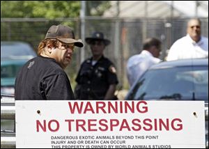Sam Mazzola, left, arrives at his exotic animal farm Friday in Columbia Station, Ohio, where a caretaker was mauled by a bear Thursday night.