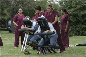 Denise Russell, a mother of two Owens students, foreground, gets a rubdown from massage therapist student Danica Spaulding.