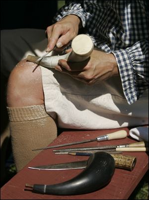 Elsewhere in the fort, re-enactor Rick Lorenzen of Traverse City but formerly of Temperance makes a powder horn. Frontiersmen kept black powder for muskets of the era in such horns.