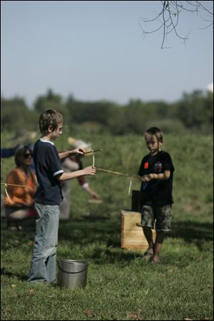 NBRS frontier01p    The Blade/Lori King  08/28/2010  Brothers Robert Searfoss, 11, left, and Owen Searfoss, 7, of Bowling Green, make candles during Frontier Skills Weekend at Ft. Meigs in Perrysburg, OH.
