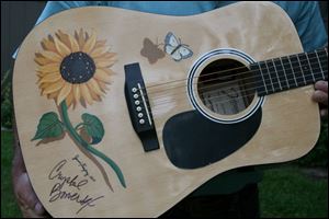 Local artist Jenni Freytag painted sunflowers and butterflies on the guitar that Crystal Bowersox autographed for The Butterfly House.