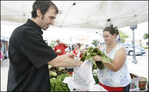 Tony House, executive chef at Navy Bistro, buuys produce from Becky Kornmeier at Andy Keil's Greenhouse stall at the Perrysburg Farmers' Market.