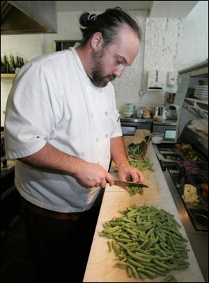 Chef Michael Bulkowski cuts green beans for a halibut dish at his Findlay restaurant, Revolver.