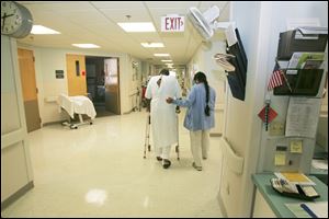 Tony Leno uses a walker and the help of physical therapist Neelam Patel on one of his last days as a patient in St. Charles.