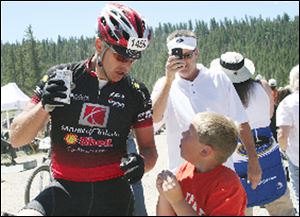 Matt Thourot of Maumme stops for some refreshment and a chat with his son, Dekker, at the Leadville Trail 100 mountain bike race.