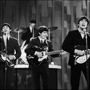 The Beatles - Paul McCartney, Ringo Starr, George Harrison, and John Lennon -perform on the 'Ed Sullivan Show' in 1964.