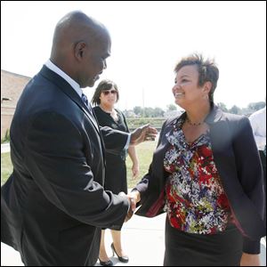 Mayor Mike Bell greets U.S. EPA Administrator Lisa Jackson after a news conference near the Maumee River in East Toledo.