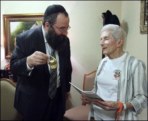 Rabbi Yossi Shemtov of Chabad House-Lubavitch offers honey to Sarah London in preparation for Rosh Hashanah, which began at sunset Wednesday.