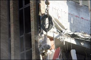 A wrecking ball smashes into the brick walls.