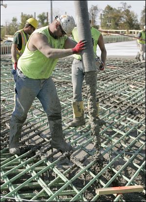 Workers pour concrete, lots of it, during the construction of the U.S. 24 overpass north of Waterville. Construction of the roadway's easternmost 6.5 miles is officially 38 percent complete and on schedule to open in summer of 2012. The state's department of transportation has said construction changes have helped shave cost from the project.