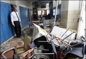 Jim Witt surveys a hallway in the school that was ripped apart by the June tornado. He said he often felt disbelief that the insurance company said the building was salvageable.