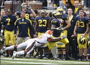 Michigan's Denard Robinson is forced out of bounds by Bowling Green's Ryland Ward in the first quarter. Robinson was hurt on the play and did not return, but he still had 129 yards rushing. Tate Forcier escapes the grasp of Bowling Green's Chris Jones.
The Wolverines piled up 721 yards of offense.