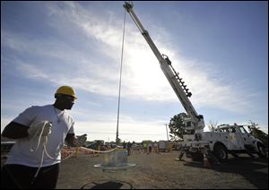 Ellis Roberts guides the weight as a fellow trainee operates the crane at Connecticut Light's facility.