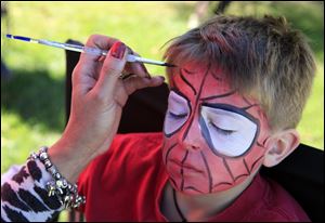 Taking up a Halloween costume theme, Jack Boeh, 9, of Maumee has his face painted to look like Spiderman.