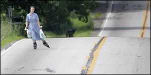 An Amish girl uses inline skates as she carries groceries in Middlefield, Ohio.