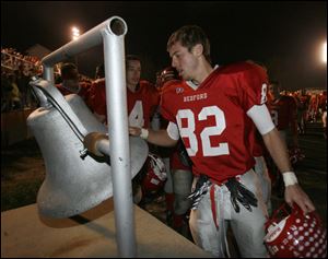 Damon Tanner rings the victory bell to celebrate Bedford's victory and the first undefeated regular season in school history.