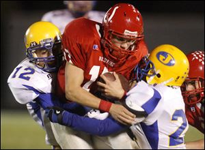 Bedford's Jared Kujawa draws Monroe Jefferson tacklers Jacob Sterling, left, and Eric Morrow. The Mules will enter the playoffs with a 9-0 record.<br>
<img src=http://www.toledoblade.com/graphics/icons/photo.gif> <font color=red><b>VIEW GALLERY:</b></font> <a href=
