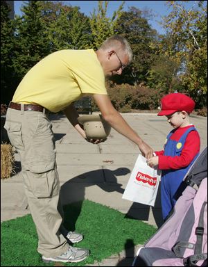 CTY littleboo22p  ZooTeen [hence, volunteer] Evan Clasey (cq), 17, of Perrysburg, gives Ethan Pooley (cq), 4, of Bowling Green, a candy at one of the trick-or-treat stations set up for Little Boos. Little Boo at the Zoo taking place again this year at the Toledo Zoo on October 21, 2010, and continuing on Friday, the 22nd. Pumpkin Path, for solder children, is Saturday and Sunday. Both events are family-friendly trick-or-treat activities. Jetta Fraser/The Blade