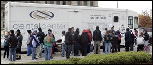 A small crowd awaits free exams at the mobile dentistry office. The service was just one of many offered to the area's homeless and underprivileged during the weekend-long event.
