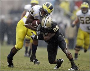Michigan tight end Kevin Koger, a Whitmer graduate, makes a catch for a first down and tries to shake Purdue cornerback Josh Johnson on a scoring drive late in the fourth quarter.