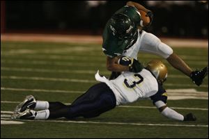CheatamNorrils of St. John's stops Justin Letts of Medina in a Division I regional semifinal game at Huron. 
