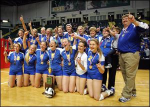 St. Ursula and coach John Buck pose with the Division I volleyball state championship trophy after their victory in the final over Dublin Coffman. The Arrows also won a state title in 2004.
