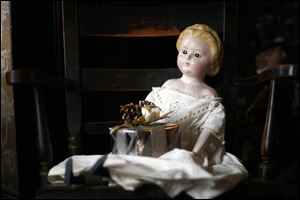 SLUG: CTY toys24p                    11/18/2010 The Blade/Amy E. Voigt               Maumee, Ohio  CAPTION:  A doll on display from the 1840's, that is wearing the original dress, on a chair near one of the decorated trees on opening day for the Joys and Toys of Christmas Past at the Wolcott House Museum on November 18, 2010.