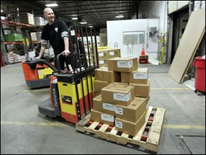 Bill Meier moves a pallet of supplies to be shipped out of the company's distribution center on Holland Road in Maumee.