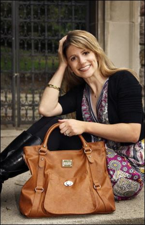 Jenna Kator shows off one of the handbags, a design named Huntington, from her new collection. Her purses are named for cities in Michigan.