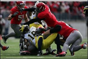Denard Robinson is sacked by the Buckeyes' defense. Robinson had a big first half but was slowed by an injury in the second.