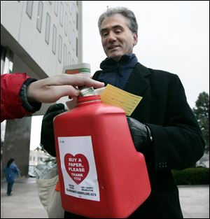 CTY newsboys04p 12/03/10  The Blade/Dave Zapotosky Michael Murnen of the Old Newsboys watches as a donor 