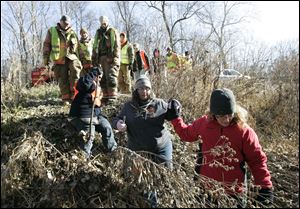 CTY missing29p 11/28/10  The Blade/Dave Zapotosky A group of searchers descend a hill on Ranger Highway in Morenci, Michigan, so they can begin a search for the missing Skelton children, in a wooded area along Lime Creek, Sunday, November 28, 2010.  Summary:  Search for missing Skelton children in Morenci, Michigan.