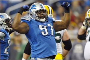 An exuberant Lions defensive tackle, Sammie Lee Hill, flexes his muscles after sacking Packers' quarterback Matt Flynn.