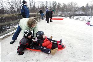 ROV sledding29p  The Blade/Lori King  12/29/2010  Melissa Salazar pushes her sons, Sammy, 7, and Zachary, 4, down the new sledding hill at Side Cut Metropark in Maumee, Ohio. The family moved to Perrysburg from Florida this summer. This is the 2nd time the boys have ever sledded (their first time was yesterday on this hill).