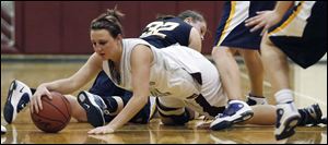 Julie Swartzmiller tries to get past Woodmore's Andrea Bouldin in a Genoa home game. Swartzmiller, a senior, is one of the top three scorers on the Comets' team. 