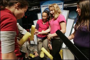 CTY learning21p   1/19/11  The Blade/Dave Zapotosky Student from Raymer Elementary School in Toledo, including from left, Kiann Massey, 11, Alannah Graves, 11, Sarabeth McAdams, 11, and Yisenia Ruiz, 10, react as the platform they were building build collapses at the Earthquake Platform station, part of the new ENGINEER IT! exhibit at the Imagination Station in Toledo, Thursday, January 20, 2011.