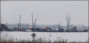 Derailed cars litter an open area near the intersection of Cass Township Roads 247 and 243 in Hancock County. The roads remained closed in the area last night. The fire could burn for three days. 