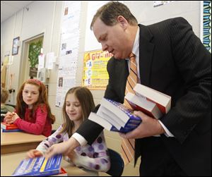Among the students receiving thesauruses and dictionaries from Richard Carr, right, on behalf of the Maumee Rotarians, are Jordan Saleh, left, and Molly Brady.