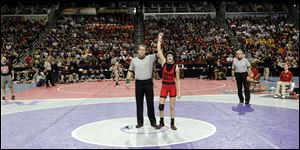 Cedar Falls' Cassy Herkelman has her arm raised in victory at the Iowa State tournament Thursday after a default. It is the first win for an Iowa female wrestler.