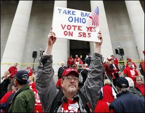 Richard Ringo, a members of The Ohio Liberty Council, a coalition of over 60 tea party groups and liberty minded organizations across Ohio, holds a sign in support of Senate Bill 5 at the Ohio Statehouse on Thursday in Columbus.