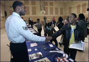 Air Force recruiter Patrick Jefferson shakes hands with Devante Rice, 18, during an after-school college fair at the James C. Caldwell Center in North Toledo. 