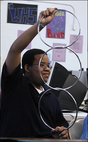 Terrance Allen, 12, tries to separate rings during a magic show at the James C. Caldwell Center. The center is the site of a School Safe Haven program that offers snacks and activities including help with homework, cooking lessons, financial education, and basics such as manners and etiquette.