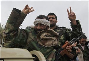 Gunmen flash the victory sign as they drive through Benghazi, Libya, now under rebel control. Thousands held a rally in the city to support Tripoli, where protesters are fighting armed supporters of Muammar Kaddafi.