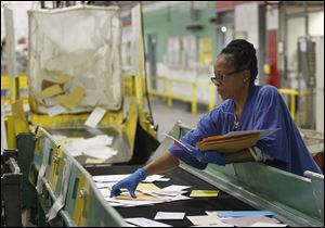 Terry Robinson sorts mail at the U.S. Post Office downtown. Some say the consolidation got off to a slow start because the Toledo facility was understaffed and overwhelmed with mail from elections and the holidays.