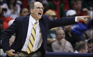 Whitmer head coach Bruce Smith shouts instructions to the boys basketball team, which beat St. John's Jesuit for the City League title and finished the year with a 19-1 record.
