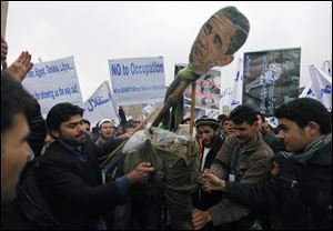 An effigy of President Obama is prepared for burning during a protest in Kabul. Hundreds of left-wing political party supporters marched through the city streets Sunday to protest U.S. military operations and demand withdrawal of foreign troops.