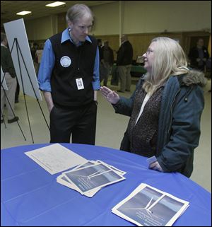 Mark Deveraux, a representative of Consumers Energy, talks with Brenda Reyome of Palmyra, Mich., during the Blissfield Wind Energy open house. A meeting of Ogden Township trustees will be held at 7 tonight in the Ogden Township Hall in Blissfield to discuss the potential impact of wind energy. 