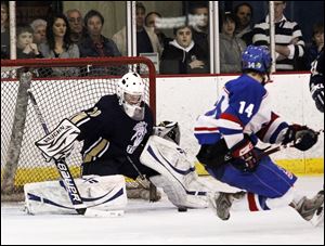 Scott Wawrzyniak, a junior, of St. Francis watches his shot slide under St. John's goaltender Jackson Steltman in the district final.