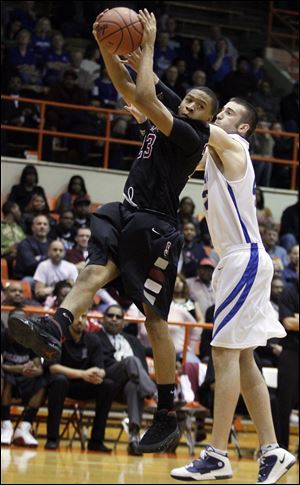 Scott's Dontonio Kynard pulls in a rebound Wednesday night in front of Defiance's Eric Stapleton.
