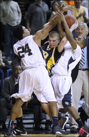Cheatham Norrils, left, and Tarvis Malone of St. John's sandwich Whitmer's Ben Syroka in the City League championship game at Savage Arena.
